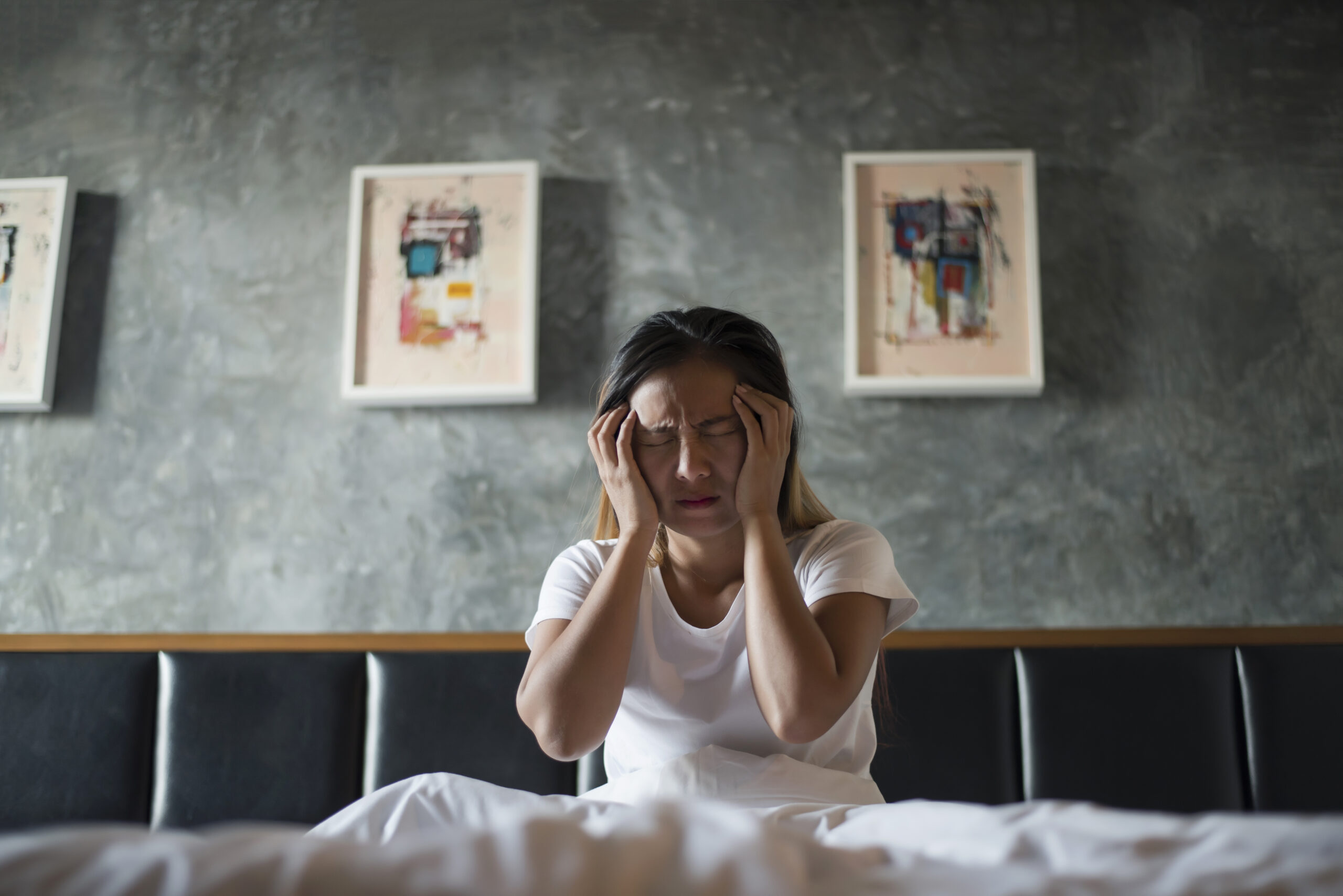 Depressed woman with headache hand holding her head on the bed